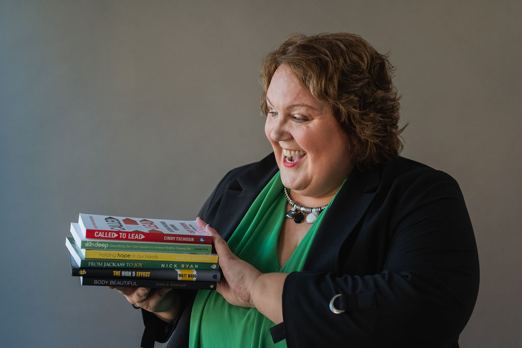 Cindy Tschosik holding a stack of books